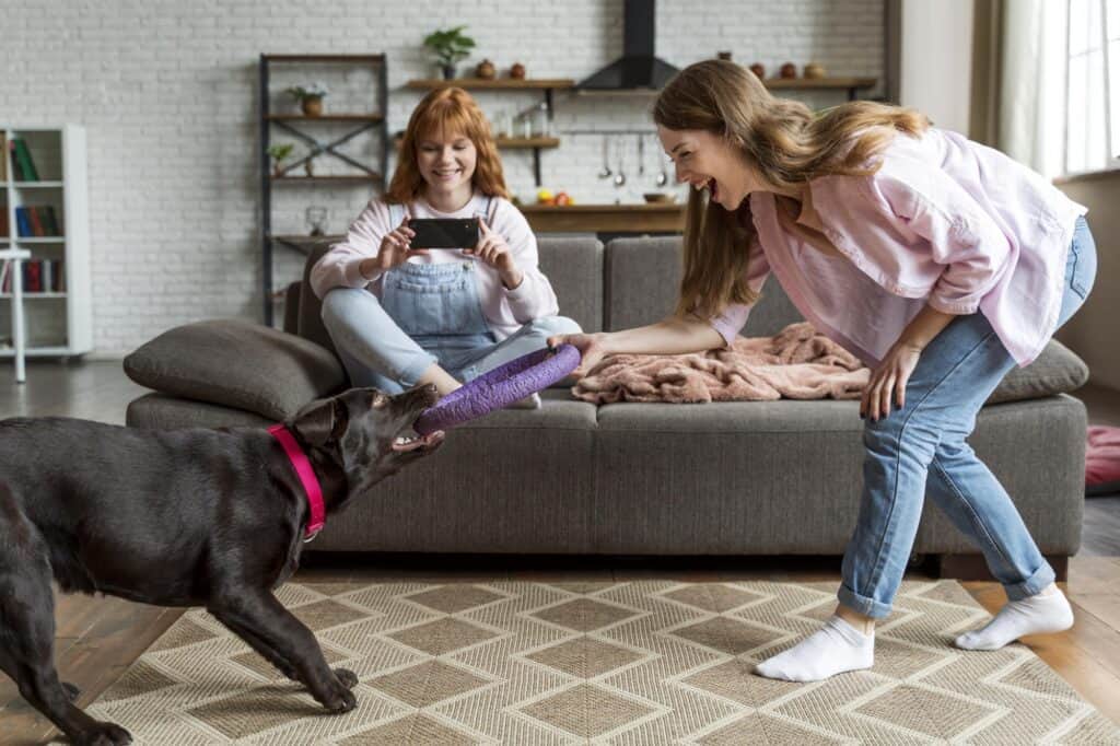 Young women playing with their dog after settling into a new home