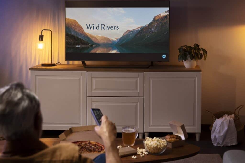 A man having a snack while watching the TV - a delicate item for the move