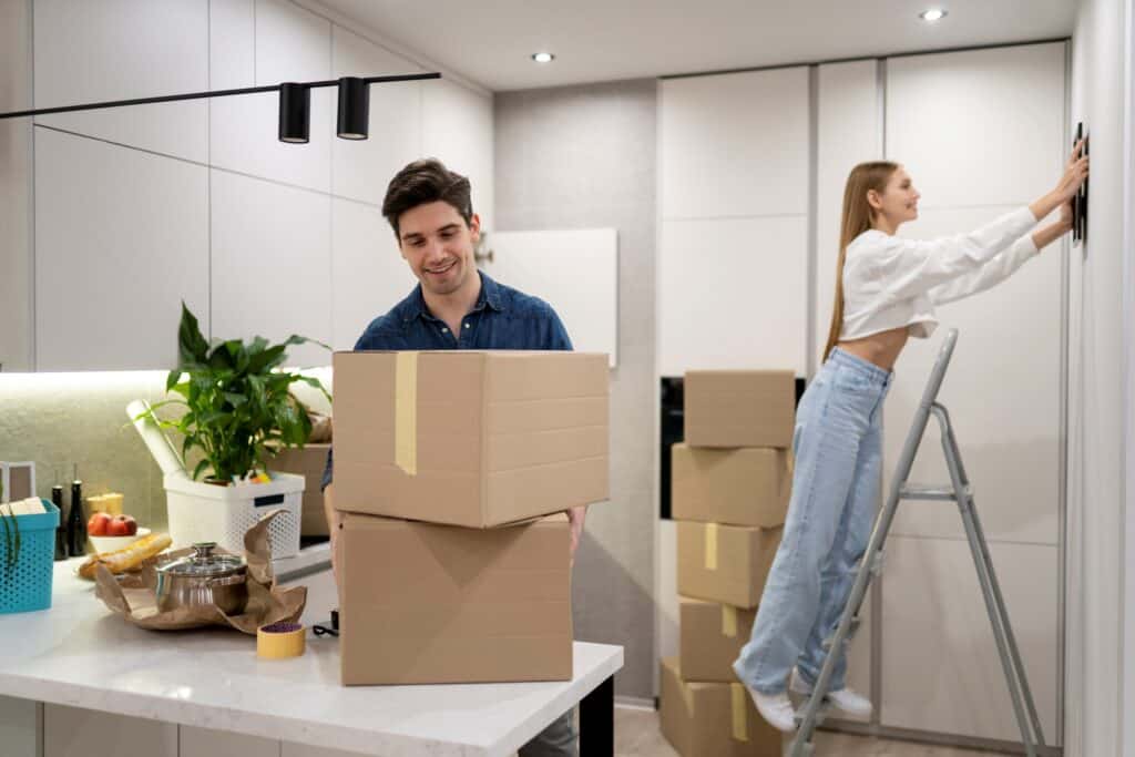A young couple setting up the kitchen after the relocation