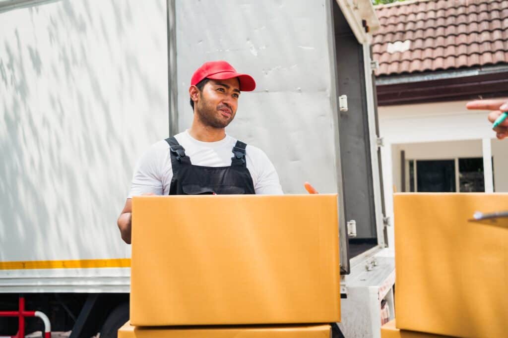 A traditional mover at the back of the truck carrying boxes