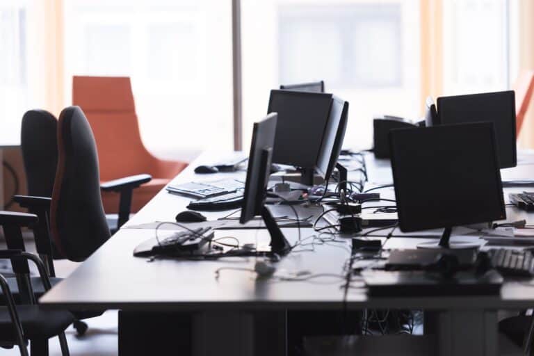 A modern office with desktops and large office chairs during lunch break